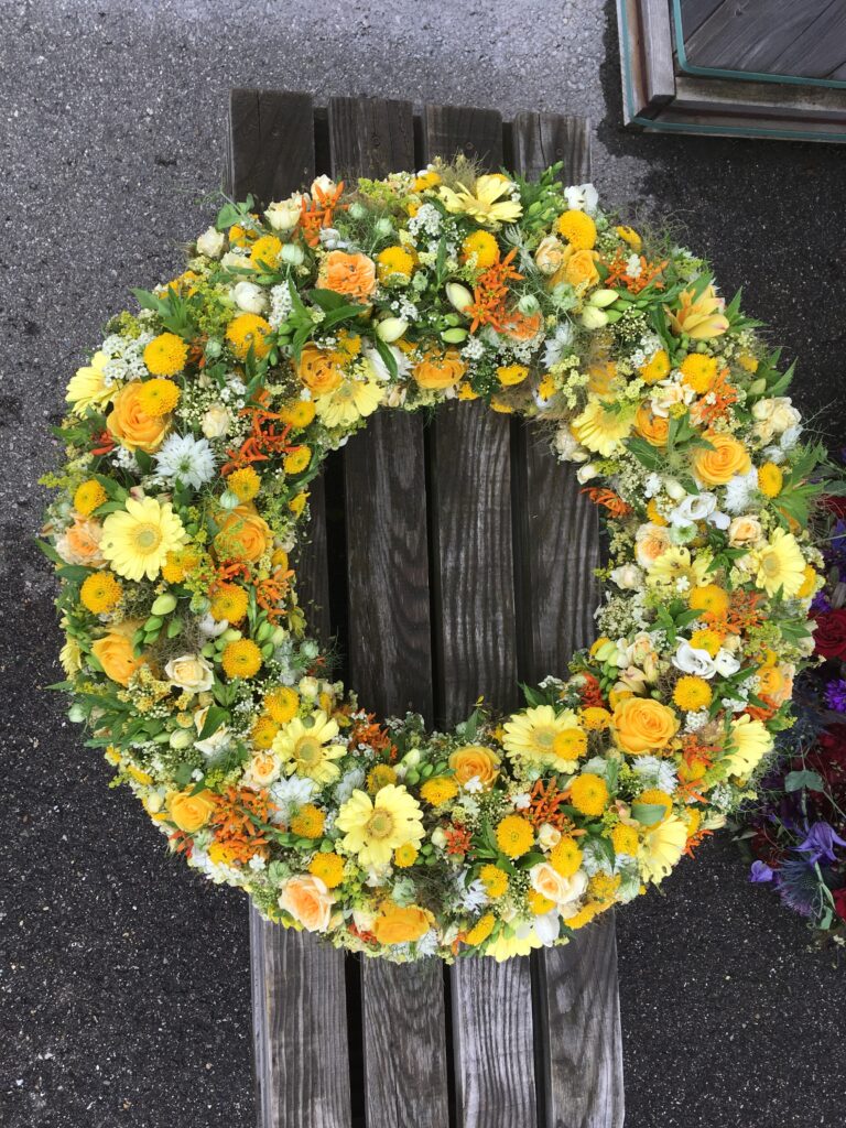 Gelber runder Trauerkranz von Meisterfloristin Maria Ebner in St. Johann in Tirol